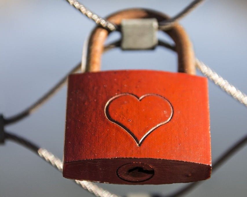 Image of red padlock with heart engraved on the front.
