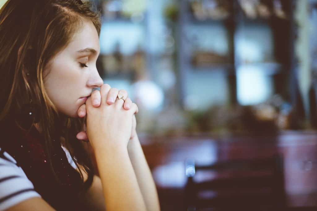 Woman praying about how to trust God.