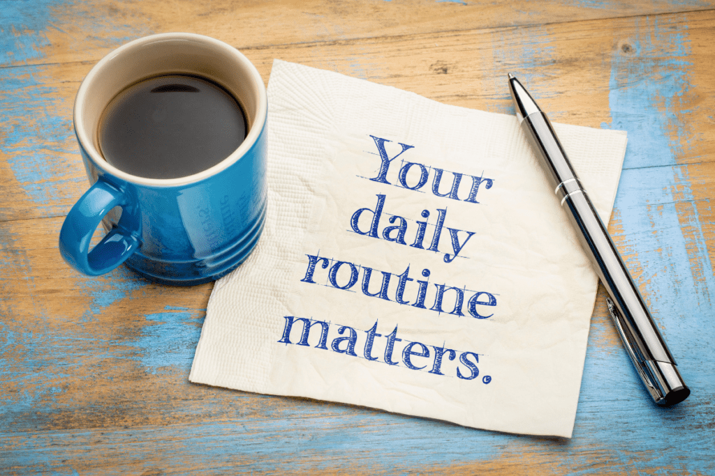 Image of a cup of coffee next to a napkin on which is sketched, "Your daily routine matters" in blue ink.