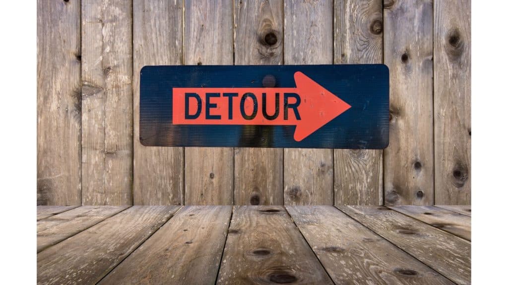 Detour sign on a wood wall.