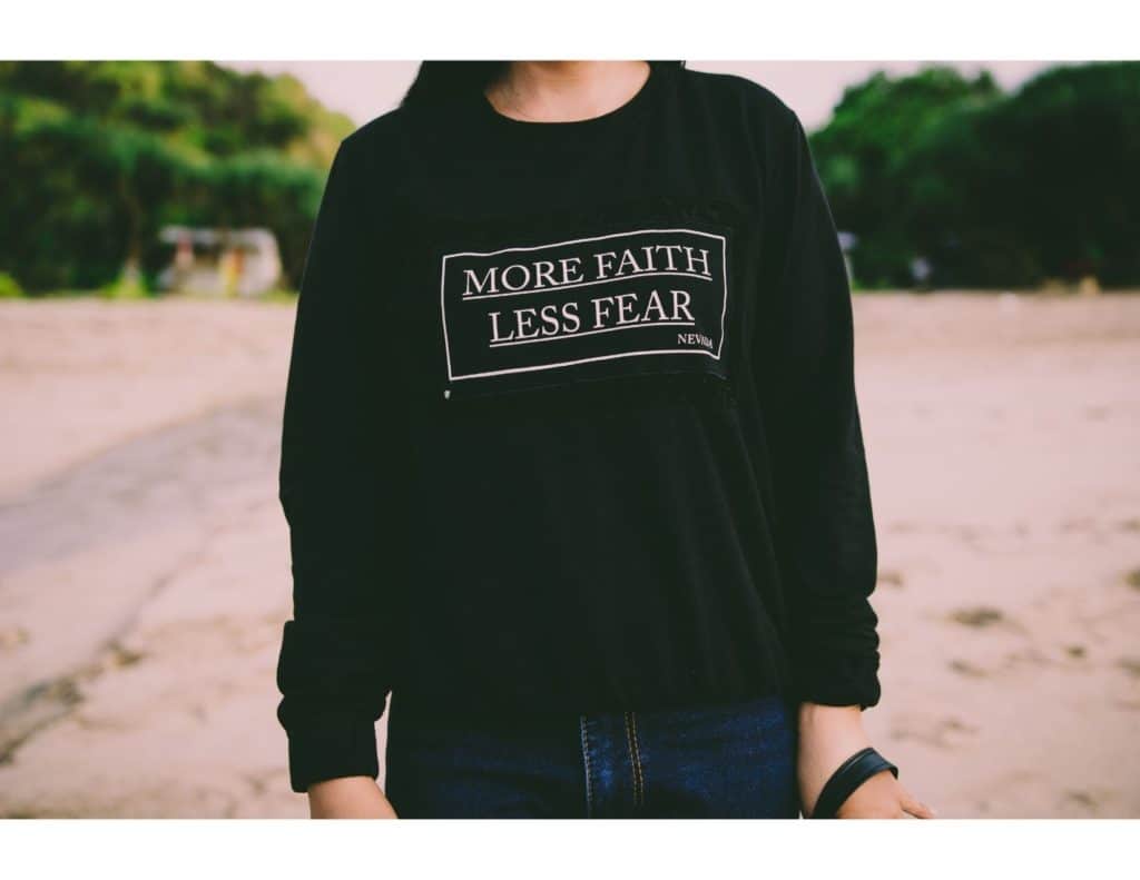 Woman wearing a shirt that says "More Faith Less Fear."