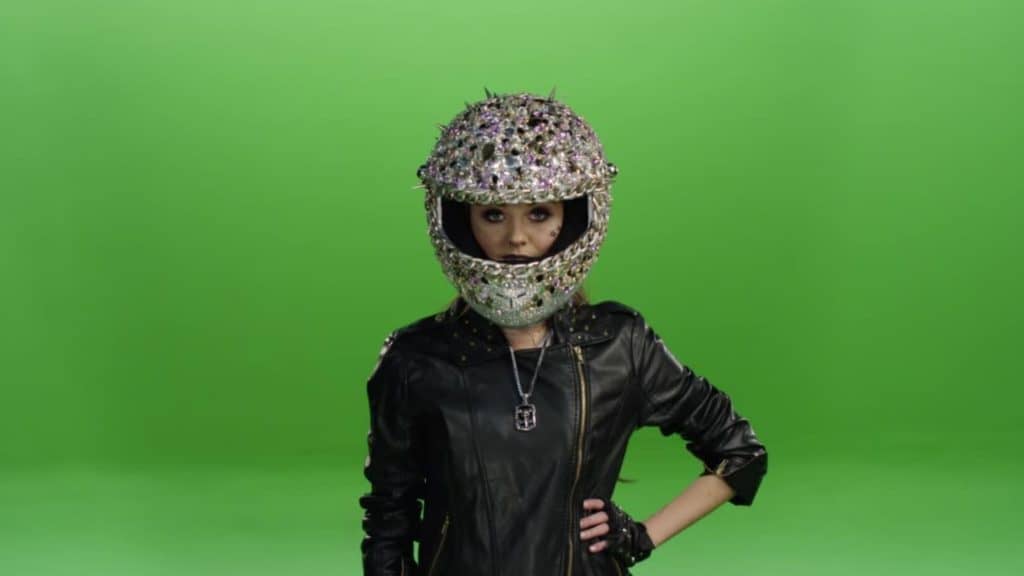 Image of a fierce-looking biker chick wearing a motorcycle helmet encrusted in jewels and silver spikes.