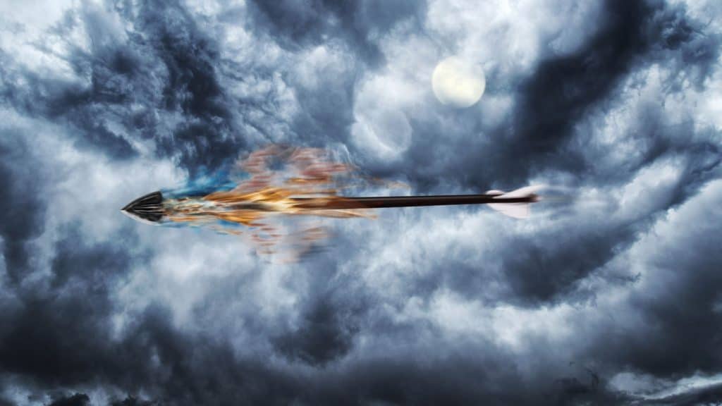 Flaming arrow flying against a cloudy sky.
