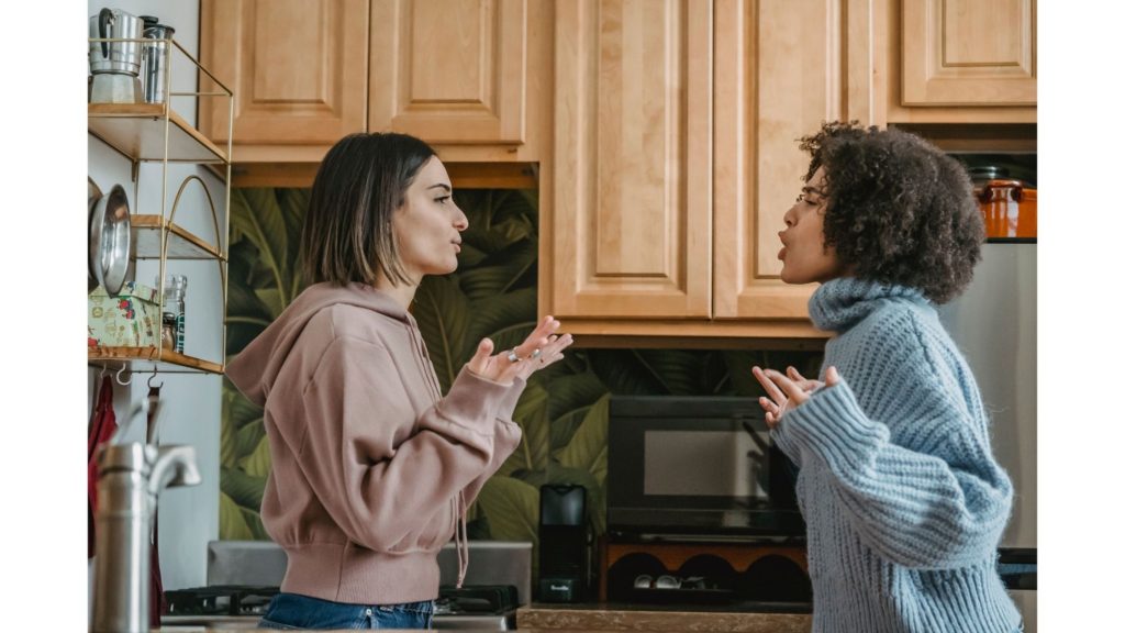 Two women arguing in a kitchen.