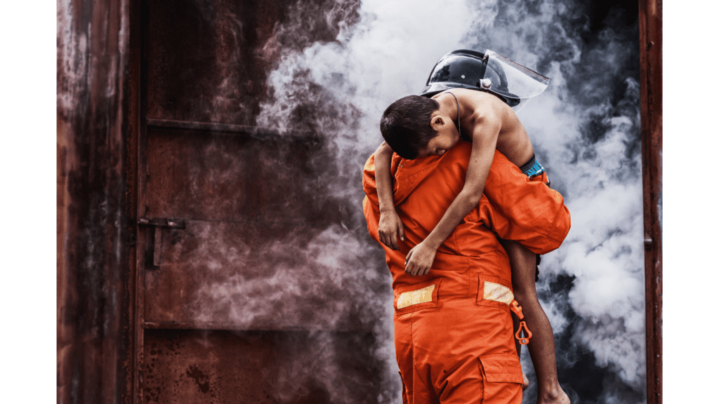 Fireman rescuing a boy from a smoky building.