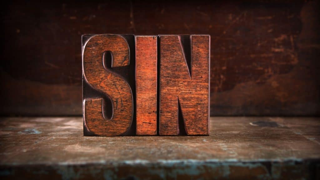 Wooden blocks carved into the word "sin"