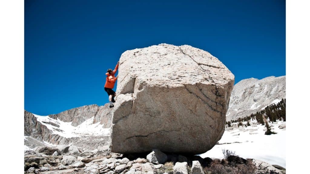 Person climbing a huge boulder.