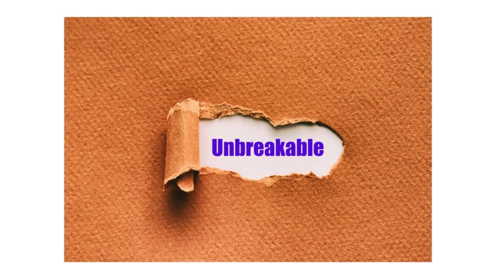 Brown paper torn to reveal the typed word "unbreakable."