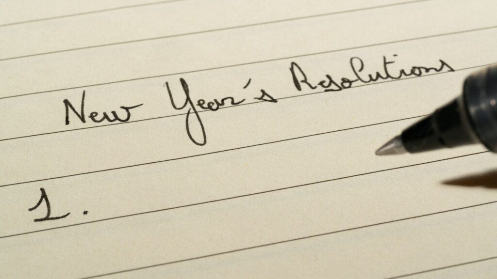 Close-up of the words "New Year's Resolutions" written on a piece of notebook paper.