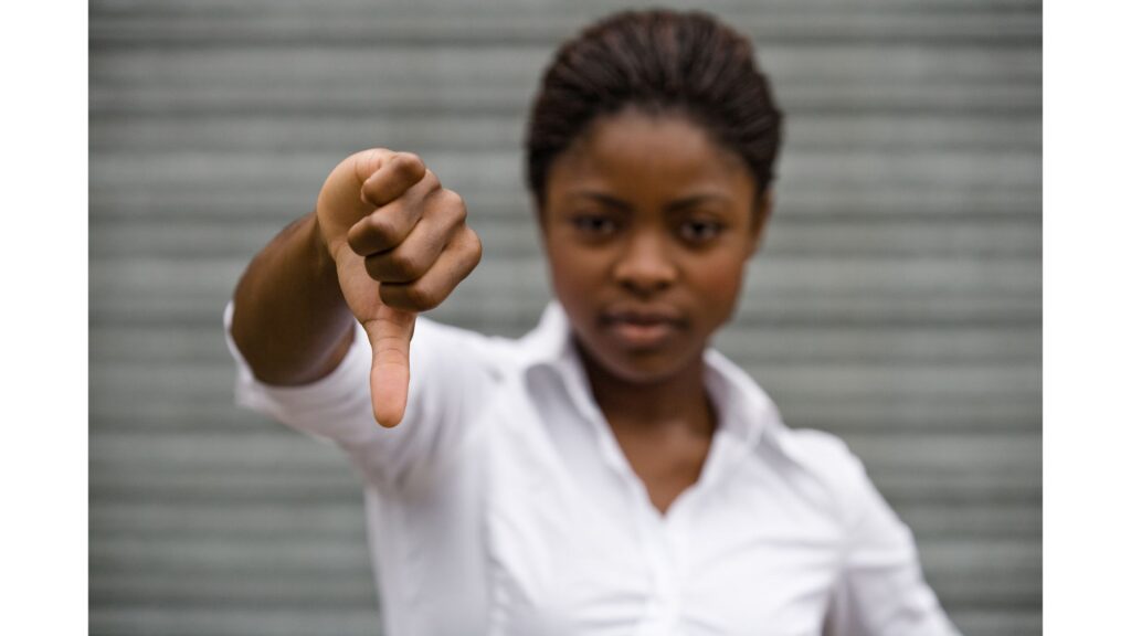 Woman making the thumbs down sign with her right hand.