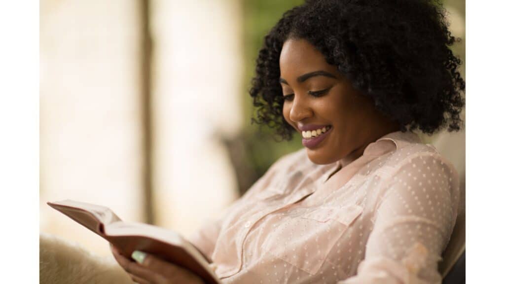 Woman smiling while resting and reading her Bible.